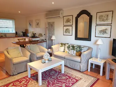 a living room with two couches and a table at Roosboom Guest Apartments in Somerset West