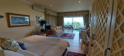 a bedroom with a bed and a living room at Roosboom Guest Apartments in Somerset West