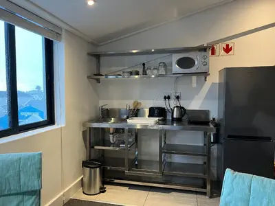 a small kitchen with a sink and a microwave at Waterfront Studio apartment no 5 in Hermanus