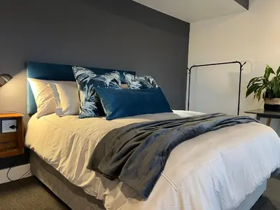 a bedroom with a bed with blue and white pillows at Waterfront Studio apartment no 5 in Hermanus
