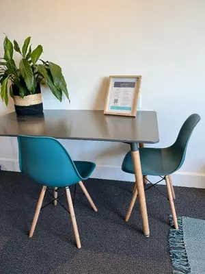 a table with two chairs and a book on it at Waterfront Studio apartment no 5 in Hermanus