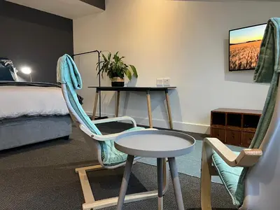 a room with a table and a chair and a bed at Waterfront Studio apartment no 5 in Hermanus