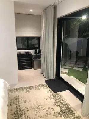 a living room with a kitchen and a sliding glass door at Stellenbosch - Winelands Living Solar in Stellenbosch