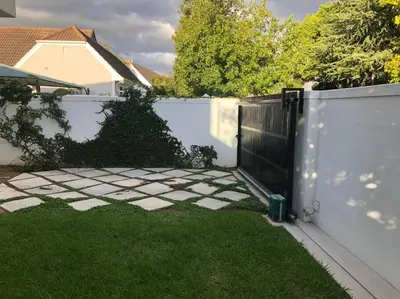 a white fence with a gate in a yard at Stellenbosch - Winelands Living Solar in Stellenbosch
