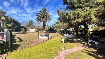 a park with palm trees and a fence at Lagoon Lodge in Cape Town