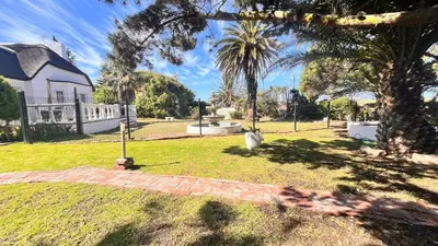 a yard with a house and a palm tree at Lagoon Lodge in Cape Town