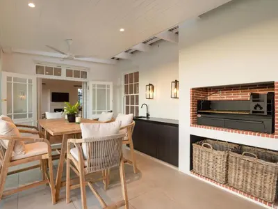 a dining room with a fireplace and a table and chairs at Mount Vernon Manor in Klapmuts