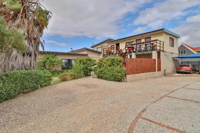 a house with a car parked in front of it at Fisherhaven Travellers Lodge in Hermanus