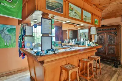 a bar in a restaurant with two stools at Fisherhaven Travellers Lodge in Hermanus