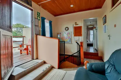 a living room with a view of a porch at Fisherhaven Travellers Lodge in Hermanus