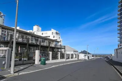 an empty street in front of a white building at 6 Culemborg Court, 5 Culemborg Street, Strand, Cape Town in Cape Town