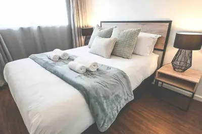 a bedroom with a large bed with towels on it at 6 Culemborg Court, 5 Culemborg Street, Strand, Cape Town in Cape Town