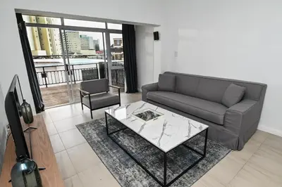 a living room with a couch and a coffee table at 6 Culemborg Court, 5 Culemborg Street, Strand, Cape Town in Cape Town