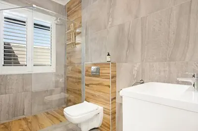 a bathroom with a white toilet and a sink at Sunset Links Villa 54 in Cape Town