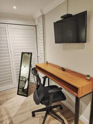 a desk with a chair and a television on a wall at 10 on Gillian Self-catering Apartments - NOT AFFECTED BY LOADSHEDDING in Eversdal