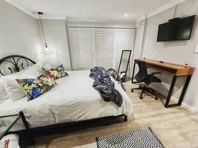 a bedroom with a bed with a desk and a computer at 10 on Gillian Self-catering Apartments - NOT AFFECTED BY LOADSHEDDING in Eversdal