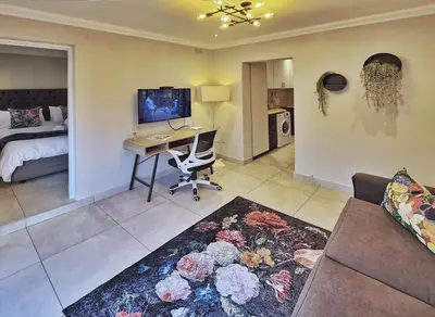 a bedroom with a desk and a bed with a computer at 10 on Gillian Self-catering Apartments - NOT AFFECTED BY LOADSHEDDING in Eversdal