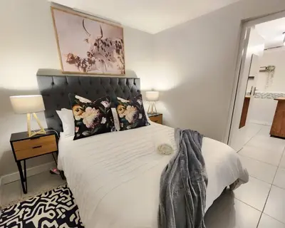 a bedroom with a large bed with white sheets and pillows at 10 on Gillian Self-catering Apartments - NOT AFFECTED BY LOADSHEDDING in Eversdal