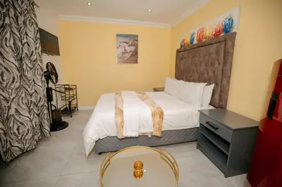 a bedroom with a bed and a table in it at BOSTON HOUSE in Cape Town
