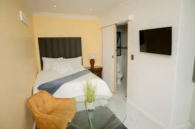 a bedroom with a bed and a glass table at BOSTON HOUSE in Cape Town