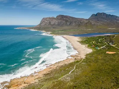 an aerial view of a beach with a mountain in the background at Klein Paradys in Kleinmond