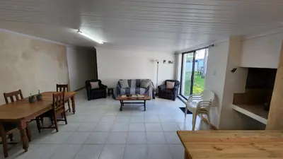 a living room with tables and chairs and a couch at Sandrivier Farm Stay in Worcester