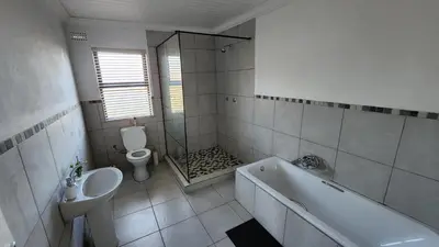 a bathroom with a tub and a sink and a toilet at Sandrivier Farm Stay in Worcester