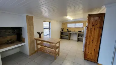 a living room with a table and a kitchen at Sandrivier Farm Stay in Worcester