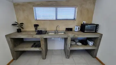 a kitchen with a wooden counter with a sink at Sandrivier Farm Stay in Worcester