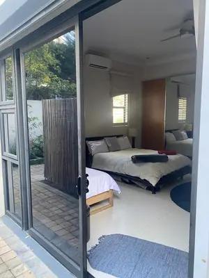 a bedroom with two beds and a sliding glass door at Big room in Stellenbosch in Stellenbosch