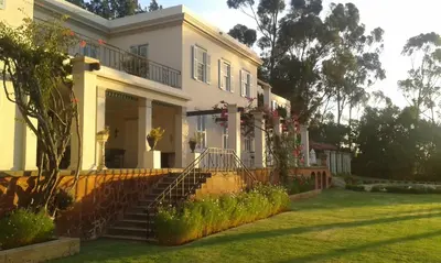 a white house with a staircase in a yard at Morton Manor in Somerset West
