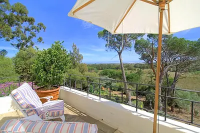 a balcony with two chairs and an umbrella at Morton Manor in Somerset West