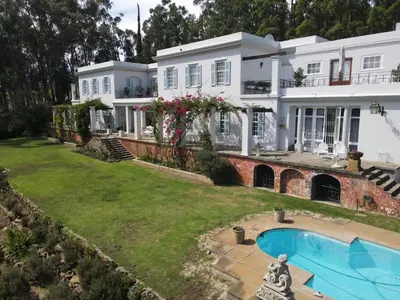 a large white house with a swimming pool in the yard at Morton Manor in Somerset West
