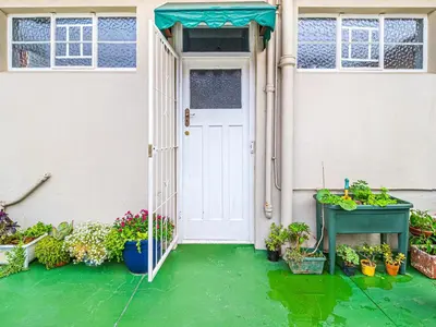 an open door to a house with potted plants at Cosy Victorian Style Full Apartment in Cape Town