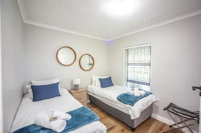 a bedroom with two beds and a mirror at @Villa de Vie holiday apartment in Cape Town