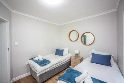 a bedroom with two beds and a mirror at @Villa de Vie holiday apartment in Cape Town
