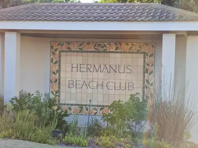 a sign for a beach club on the side of a building at Hermanus Beach Club UNIT 74 in Hermanus