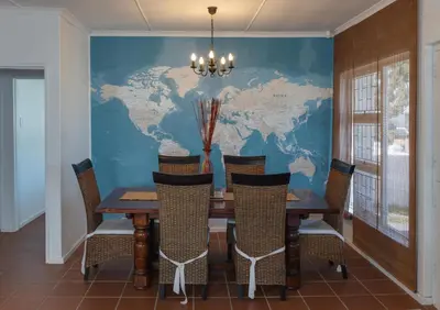a dining room with a table and a world map on the wall at SeaCrest Cottage in Hermanus