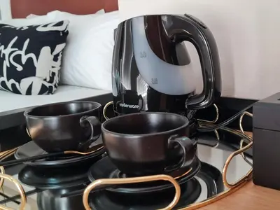 a coffee maker sitting on a stove with two cups at Aan de Paarlberg in Paarl