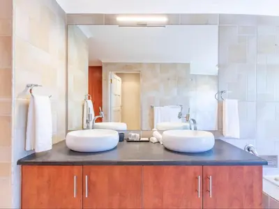 a bathroom with two sinks and a large mirror at Aan de Paarlberg in Paarl