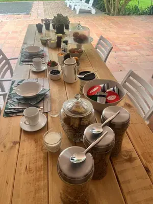 a wooden table with utensils and dishes on it at Twistniet BnB in Wellington