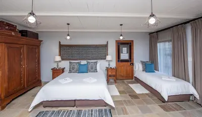 a bedroom with two beds with blue pillows at Excellent Guest House in Bellville