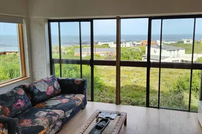 a living room with a couch and a view of the ocean at Jock's Bay View in Bettyʼs Bay