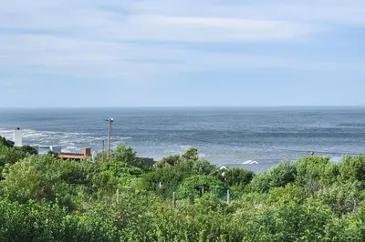 a view of a beach with the ocean in the background at Jock's Bay View in Bettyʼs Bay