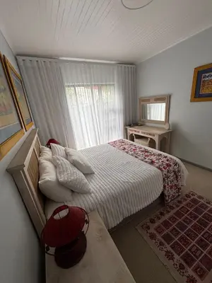 a small bedroom with a bed and a window at Self Catering Luke Drive Onrus in Hermanus