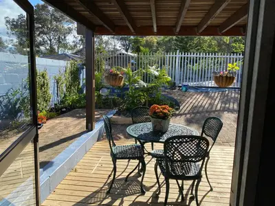 a patio with a table and chairs on a deck at Self Catering Luke Drive Onrus in Hermanus