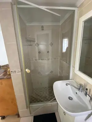 a bathroom with a glass shower and a sink at Self Catering Luke Drive Onrus in Hermanus