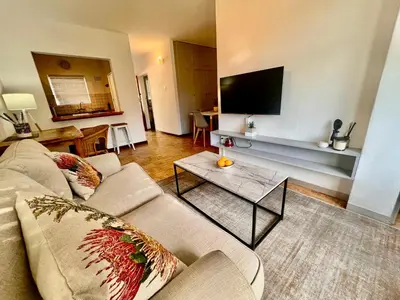 a living room with a couch and a flat screen tv at #Restyourcase in Stellenbosch