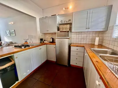 a kitchen with white cabinets and a stainless steel refrigerator at #Restyourcase in Stellenbosch