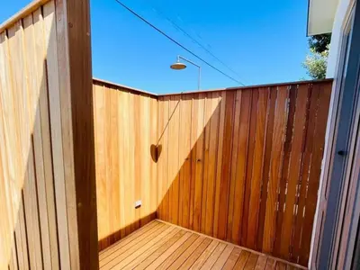 a wooden fence with a wooden floor and a window at Quaint Cottage in Hermanus